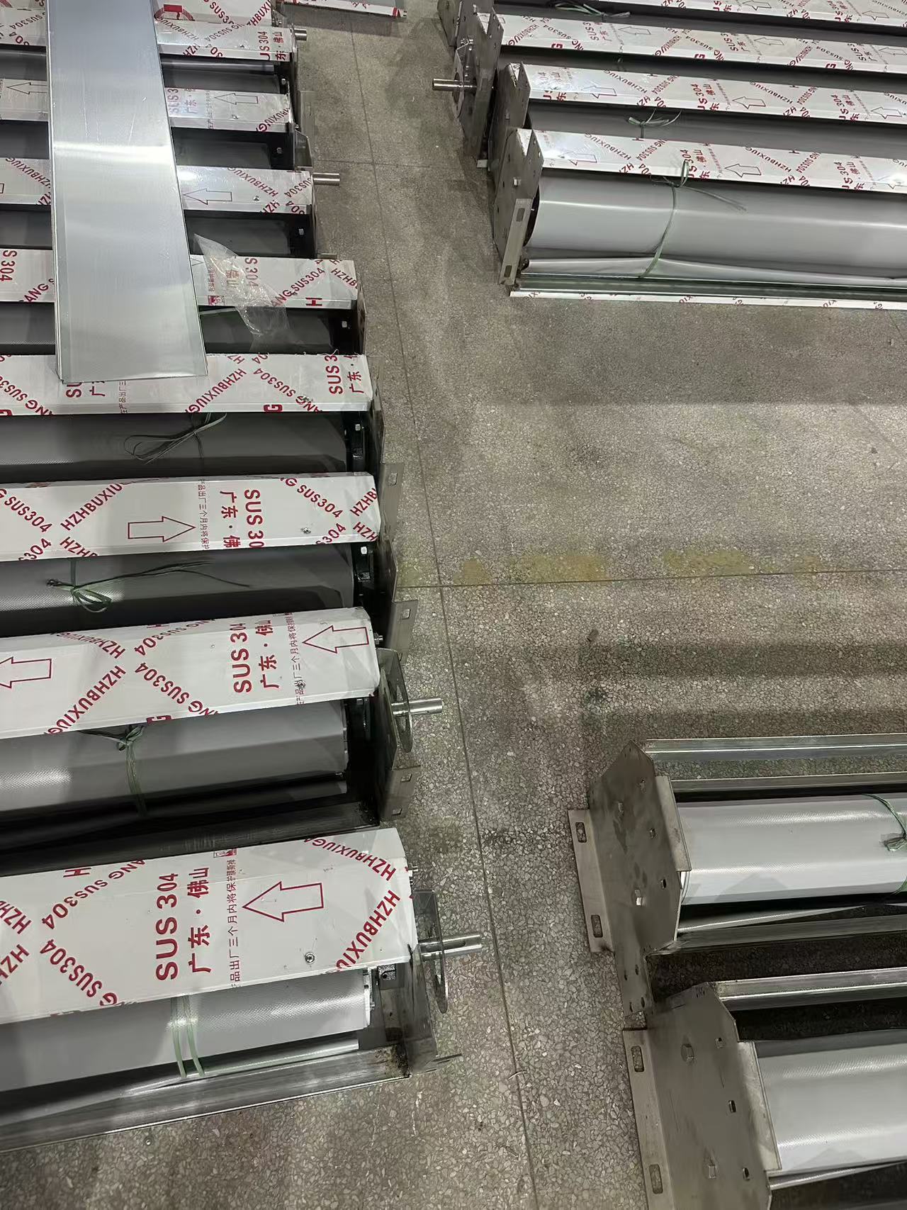 Soft-curtain rapid-door components and wrapped roller assemblies arranged on a workshop floor